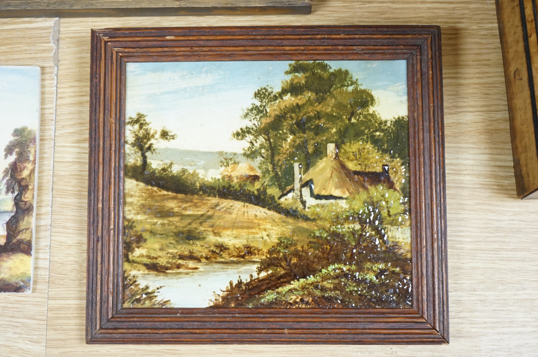 Four ceramic painted plaques depicting landscapes to include ‘Upper Lake Killard’, three framed, largest 36cm wide